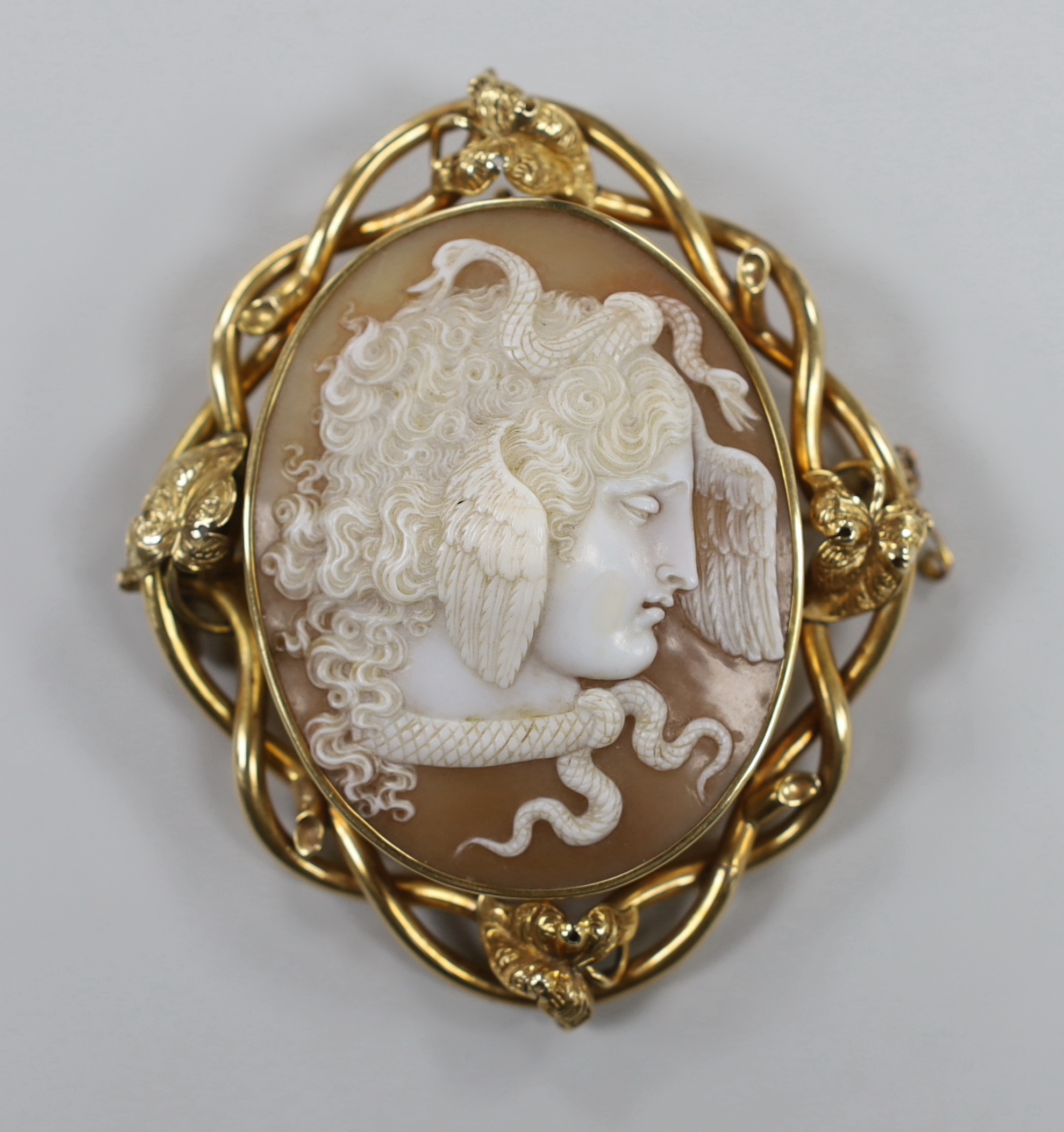 A Victorian yellow metal mounted oval cameo shell brooch, carved with the head of Medusa, 78mm.